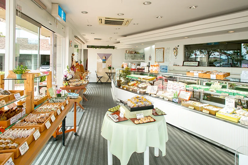 菓子が並ぶ木の棚とイートイン席のある店内